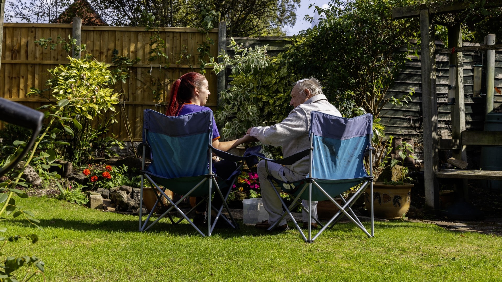 Two people sitting in a garden.