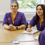 Caregivers engaged in training session, ready for local home care.